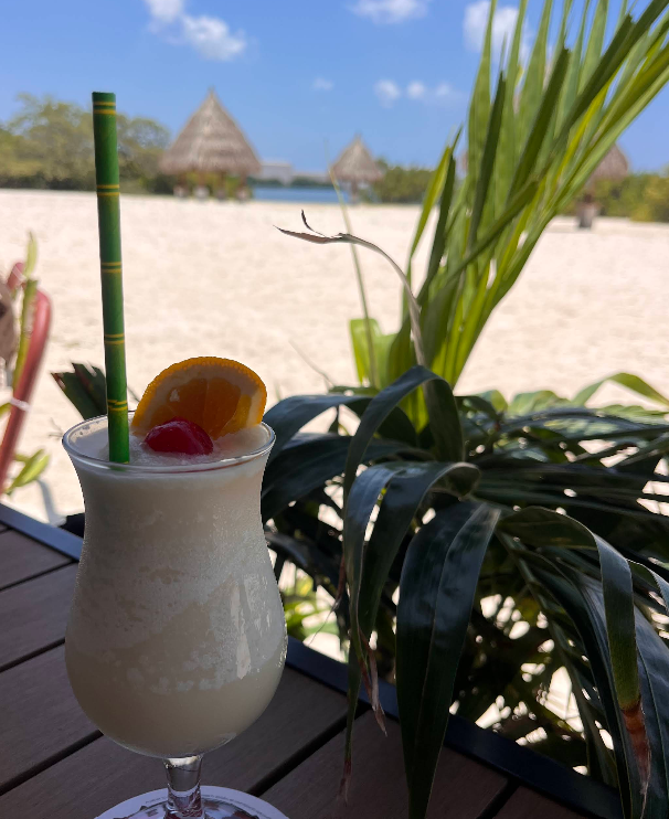 Frozen tropical cocktail on a table facing the beach
